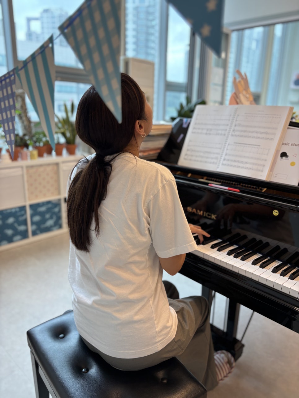 악보를 보며 연주하는 성인 수강생의 뒷모습