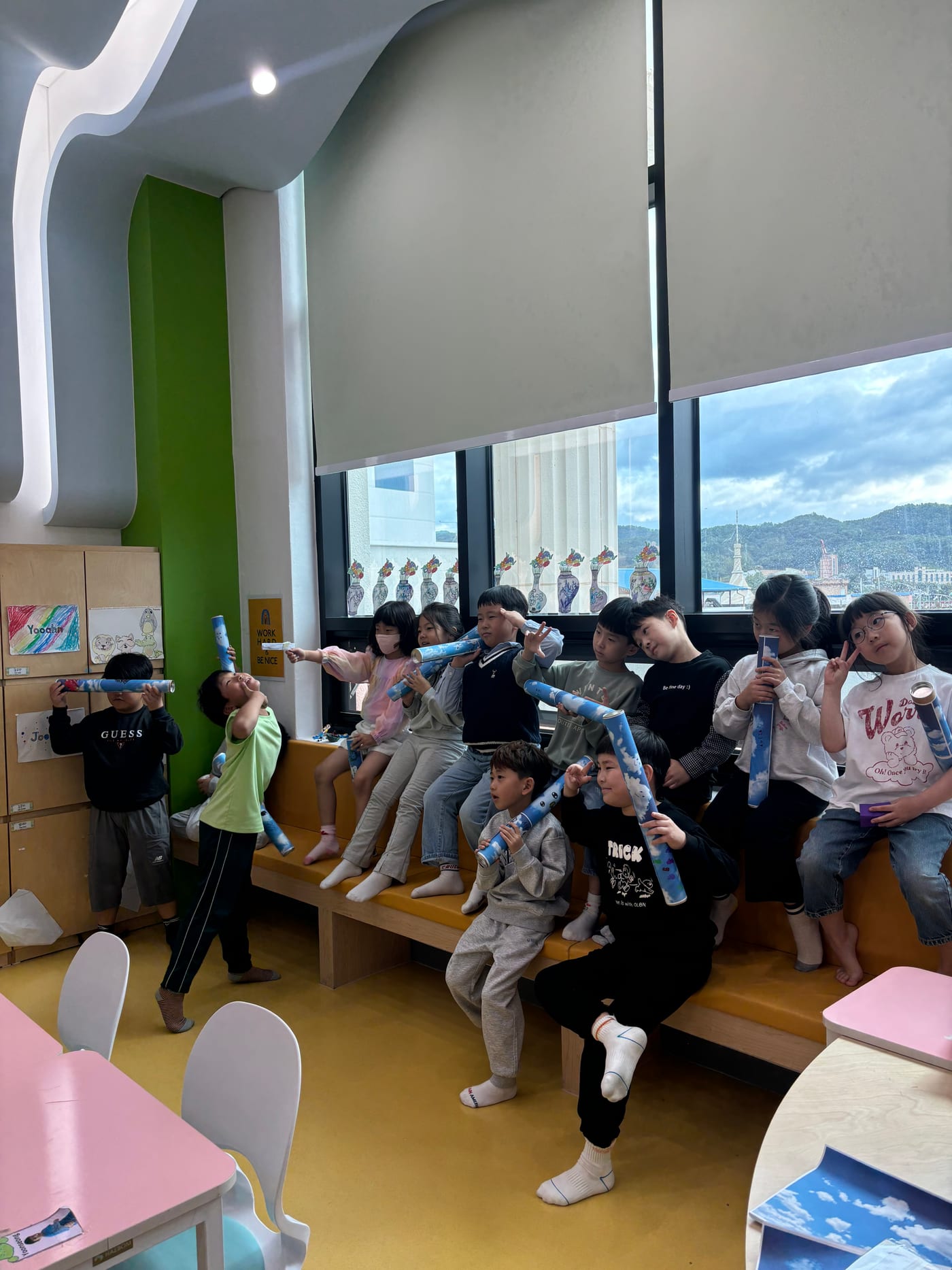 창가에 앉아 악기를 불어 보는 아이들